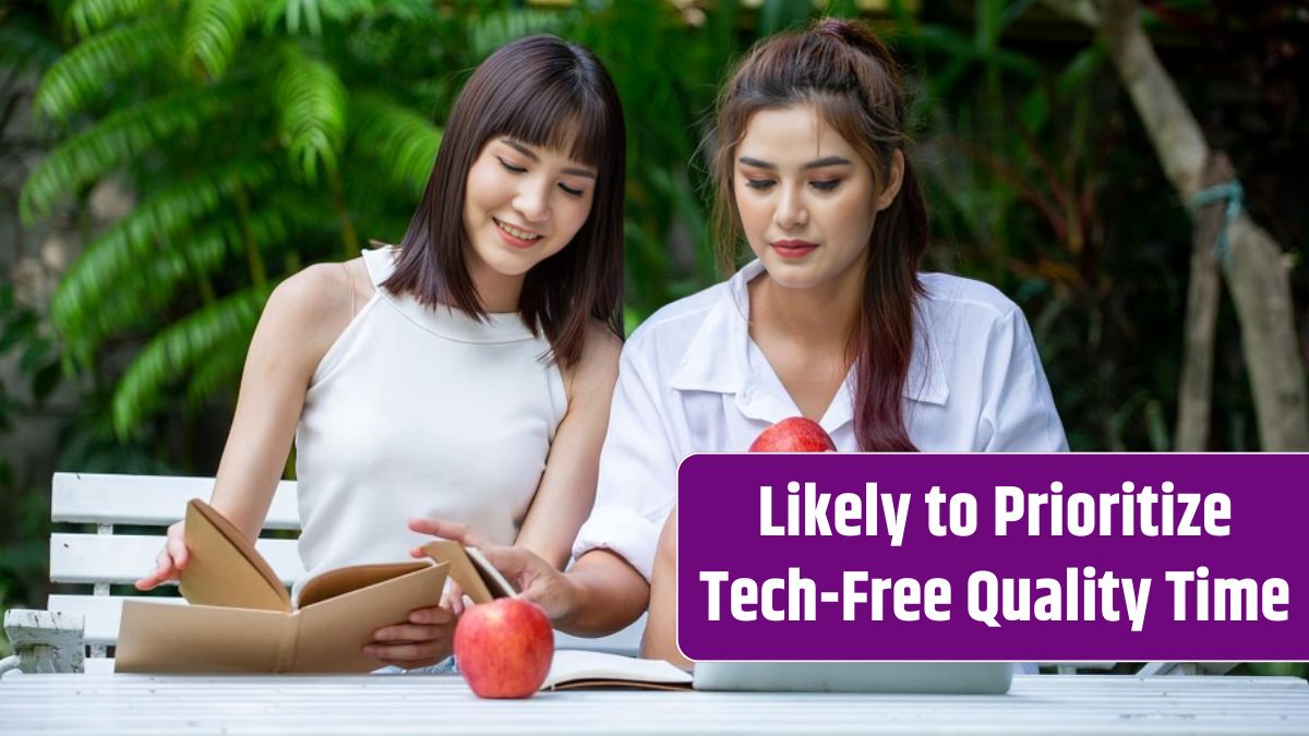 Female friends using laptop at table in yard.