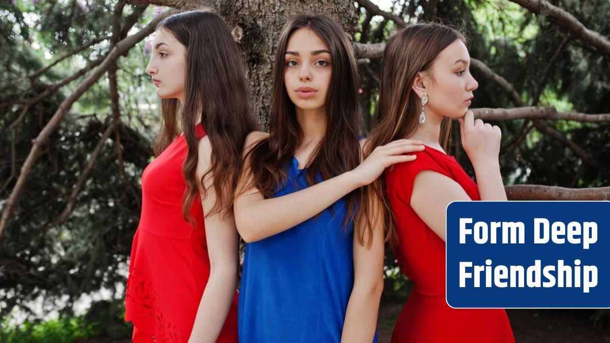 Three teenagers girl in blue and red dresses posed outdoor.